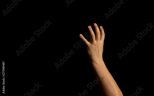 The hand of a young man on a black background