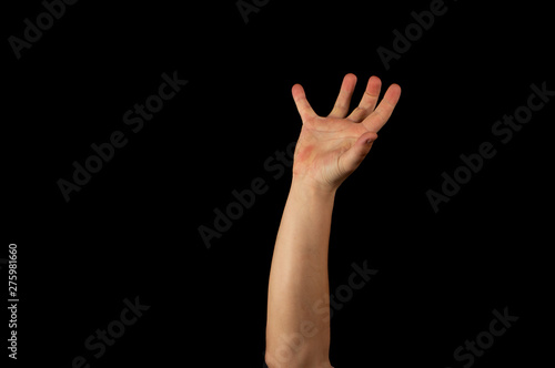 The hand of a young man on a black background