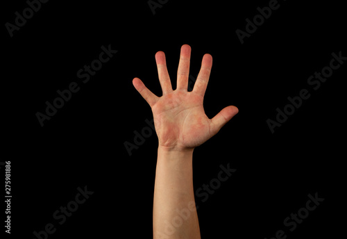 The hand of a young man on a black background