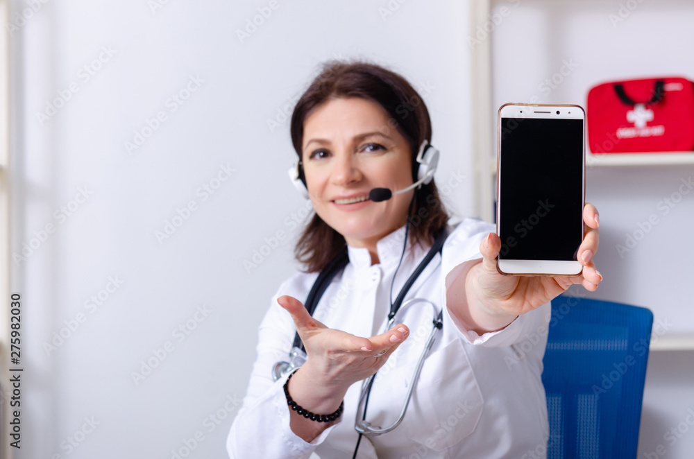 Middle-aged female doctor in telemedicine concept Middle-aged female doctor in telemedicine concept
