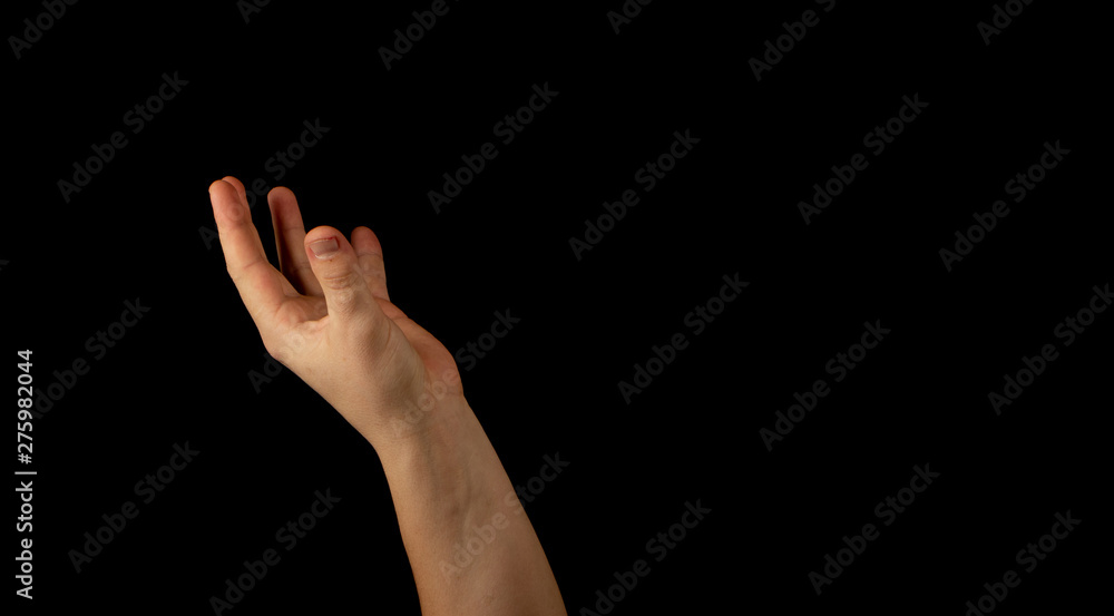 The hand of a young man on a black background The hand of a young man on a black background