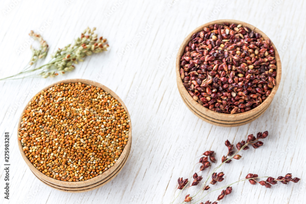 Two boxes with red and yellow millet. Sprigs of millet. White background Two boxes with red and yellow millet. Sprigs of millet. White background