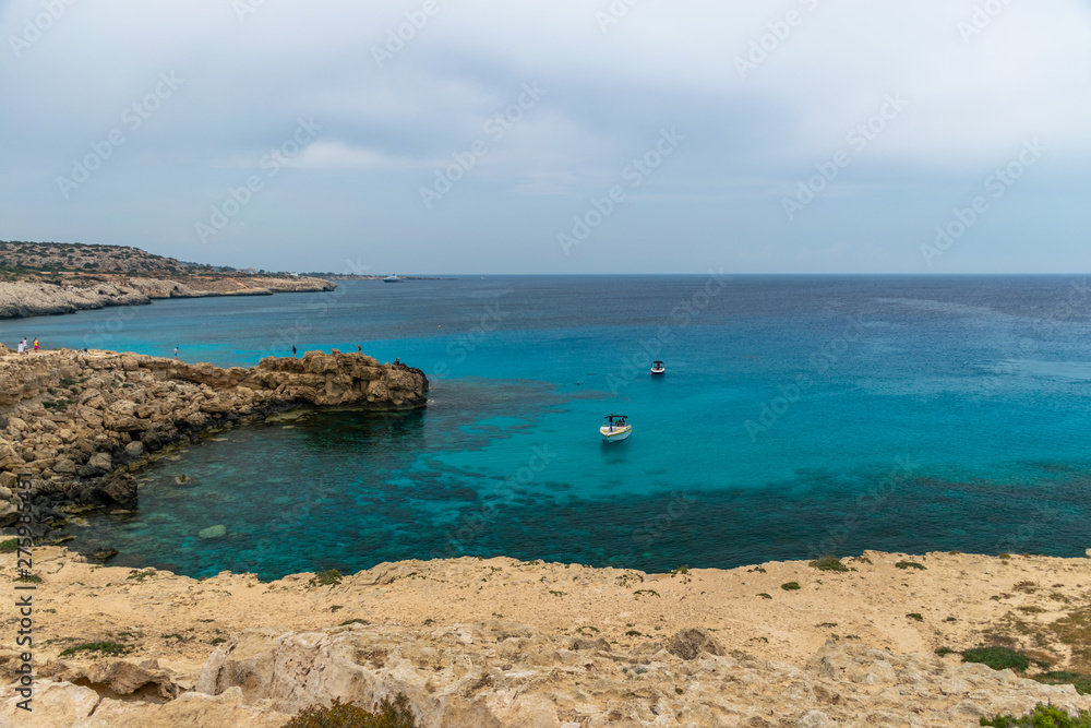 CYPRUS, CAPE CAVO GRECO - MAY 11/2018: Tourists sailed on a motor boat into the blue lagoon for swimming. CYPRUS, CAPE CAVO GRECO - MAY 11/2018: Tourists sailed on a motor boat into the blue lagoon for swimming.