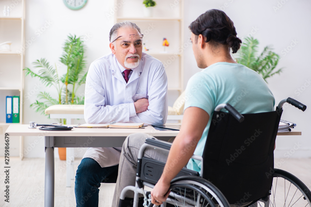 Male patient in wheel-chair visiting old doctor Male patient in wheel-chair visiting old doctor