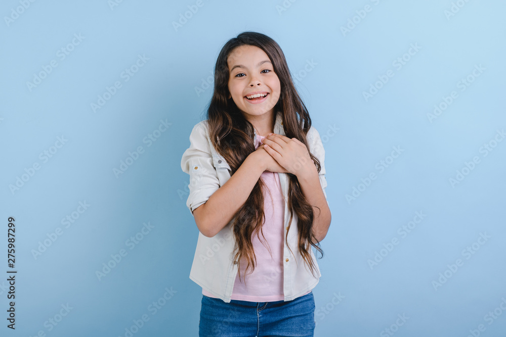 Portrait of young happy cute girl presses her hands to her chest and looking at the camera . - Image Portrait of young happy cute girl presses her hands to her chest and looking at the camera . - Image