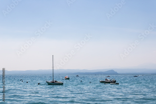 Boats with the far away mountains in Bardolino, Italy - Image