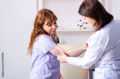 Wallpaper Mural Female doctor checking patient's joint flexibility with goniomet Torontodigital.ca