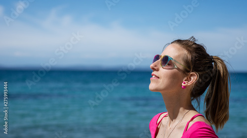 Woman standing by the sea enjoying the sunny day © Gajus