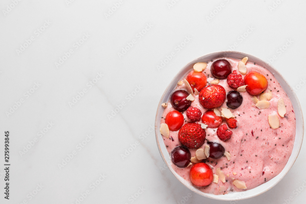 pink smoothie bowl with fresh berries, nuts and seeds on white marble table. healthy breakfast. top view pink smoothie bowl with fresh berries, nuts and seeds on white marble table. healthy breakfast. top view