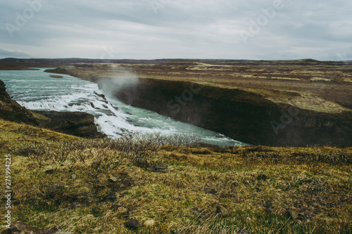 Gullfoss, one of the most beautiful destinations in Iceland. Pale green grass and cascades with turquoise water.
