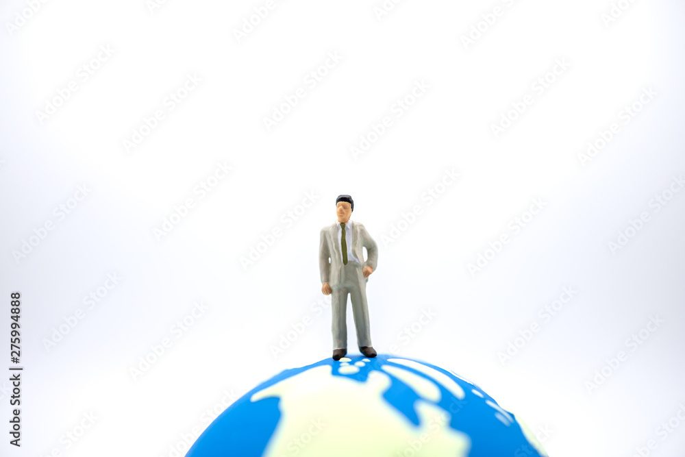 Global Business and Planning concept. Close up of businessman miniature figure standing on mini world ball on white background and copyy space. Global Business and Planning concept. Close up of businessman miniature figure standing on mini world ball on white background and copyy space.