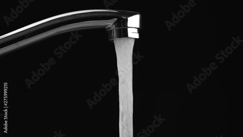 water flows from the tap on a black background