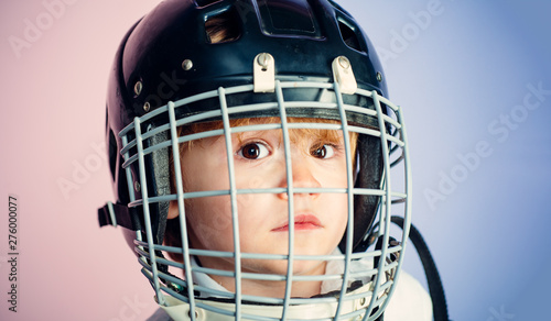 Boy cute child wear hockey helmet close up. Safety and protection. Protective grid on face. Sport equipment. Hockey or rugby helmet. Sport childhood. Future sport star. Sport upbringing and career