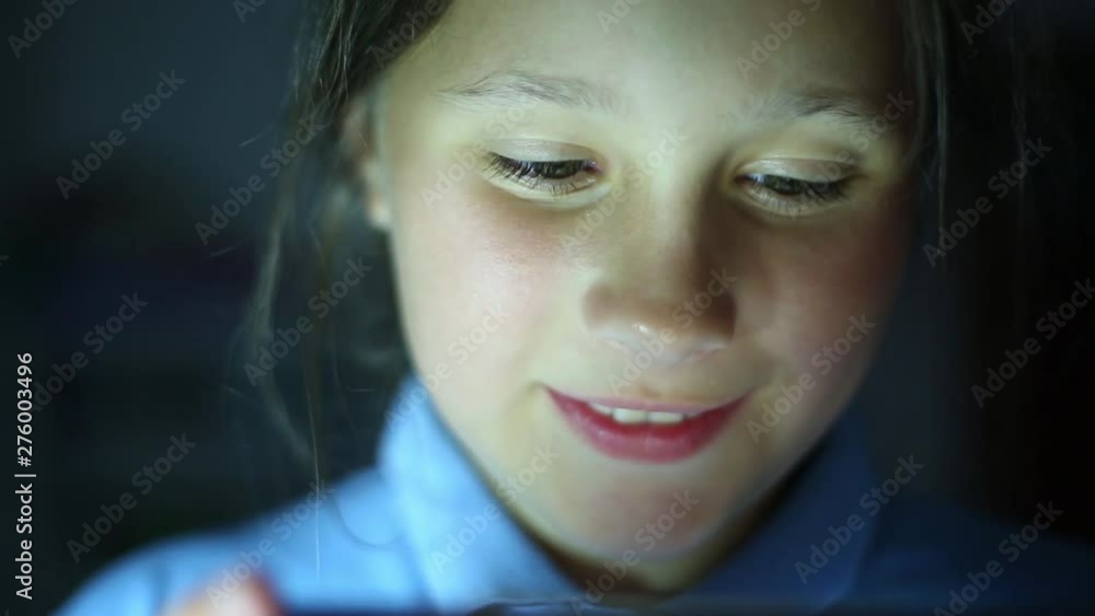 Face of smiling girl watching video on smartphone. Close-up. Face of smiling girl watching video on smartphone. Close-up.