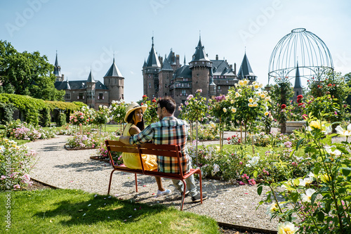 Castle de Haar Netherlands Utrecht on a bright, young couple men and woman mid age walking in the castle garden