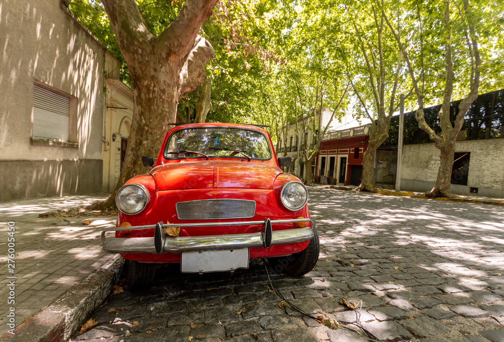 Fototapeta premium Zabytkowy czerwony samochód zaparkowany w Colonial del Sacramento