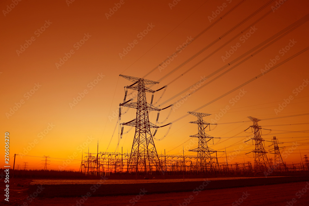 high voltage electric power steel tower in the setting sun