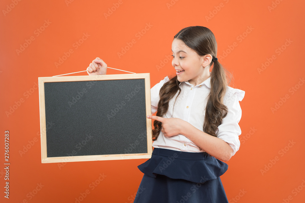 look at this. cheerful school girl with blackboard. happy pupil in school uniform. copy space. commercial marketing conept. business school advert. new shopping idea. school market sales. signage look at this. cheerful school girl with blackboard. happy pupil in school uniform. copy space. commercial marketing conept. business school advert. new shopping idea. school market sales. signage