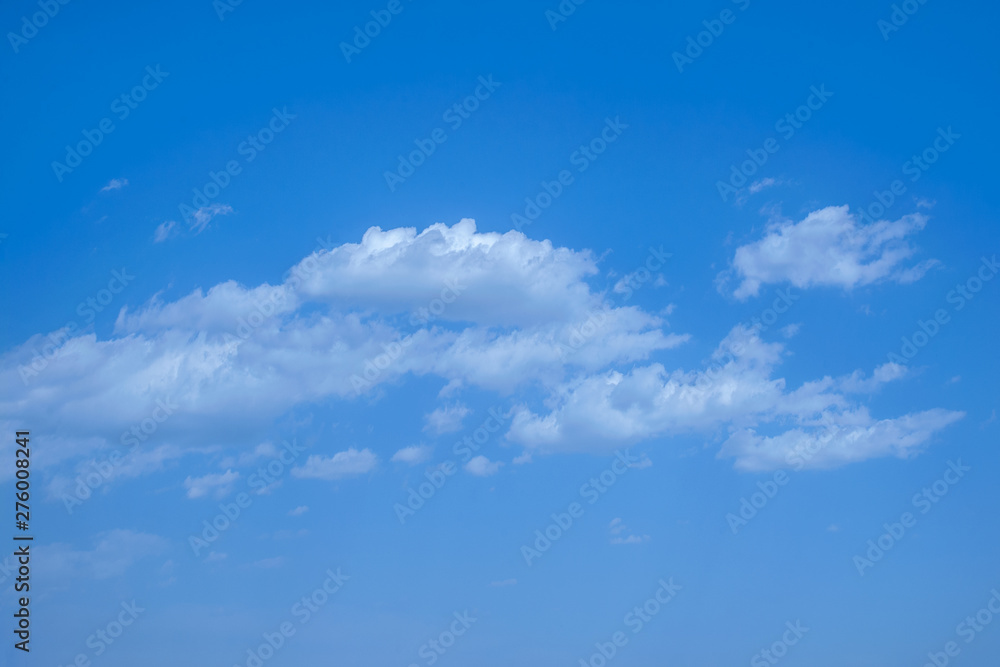 Obraz premium light fluffy clouds on a bright blue sky