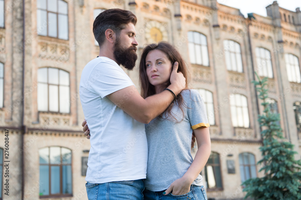 We are better when we together. Family couple hugging with building on background. Couple of bearded man and sexy woman. Sensual couple spending time together. Couple in love
