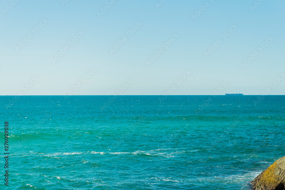 Vista de um grande navio navegando no horizonte do oceano Atlântico e uma encosta. Vista de um grande navio navegando no horizonte do oceano Atlântico e uma encosta.