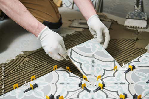 Tiler installing tile on bathroom floor. home indoors renovation