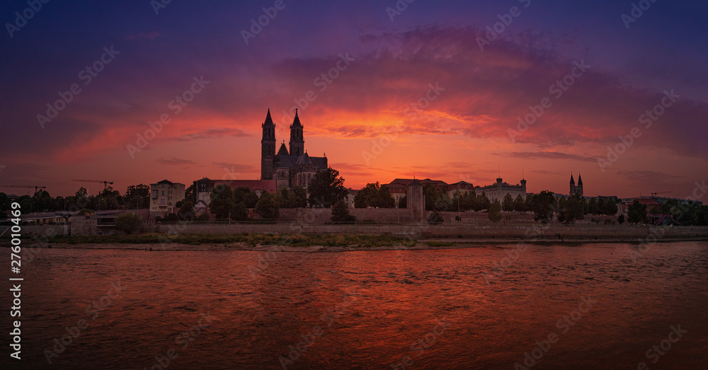 Panoramic view of bloody sunset in front of cathedral in Magdeburg and river Elbe, Germany, Summer