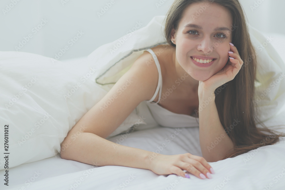 Pretty woman lying down on her bed at home. Pretty woman lying down on her bed at home.