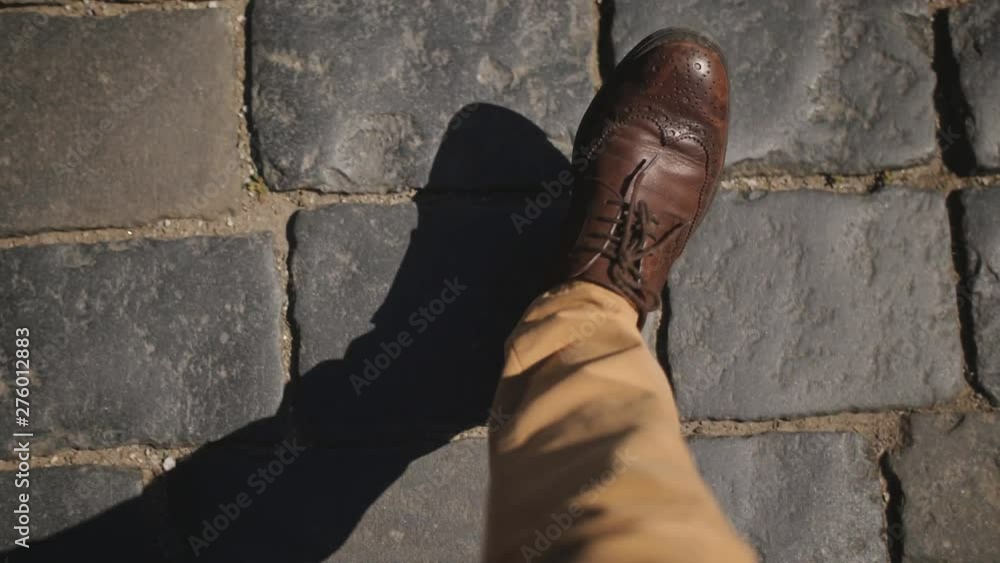 Business Man in a brown leather shoes stepping on the pavement, top view in the first person. Business Man in a brown leather shoes stepping on the pavement, top view in the first person.