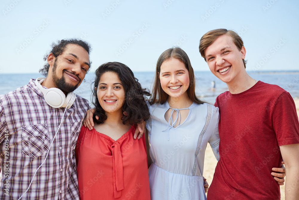Four happy young people posing at beach enjoying Summer, copy space Four happy young people posing at beach enjoying Summer, copy space