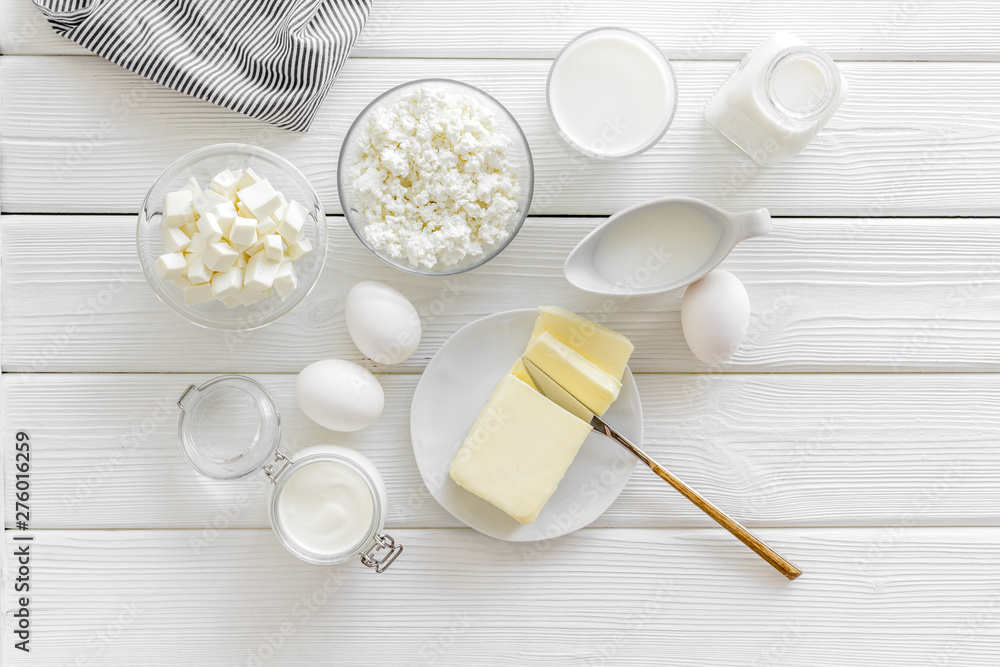 Fototapeta premium Eggs, butter, milk, yougurt, cottage for natural farm products yougurt on white wooden background top view monochrome