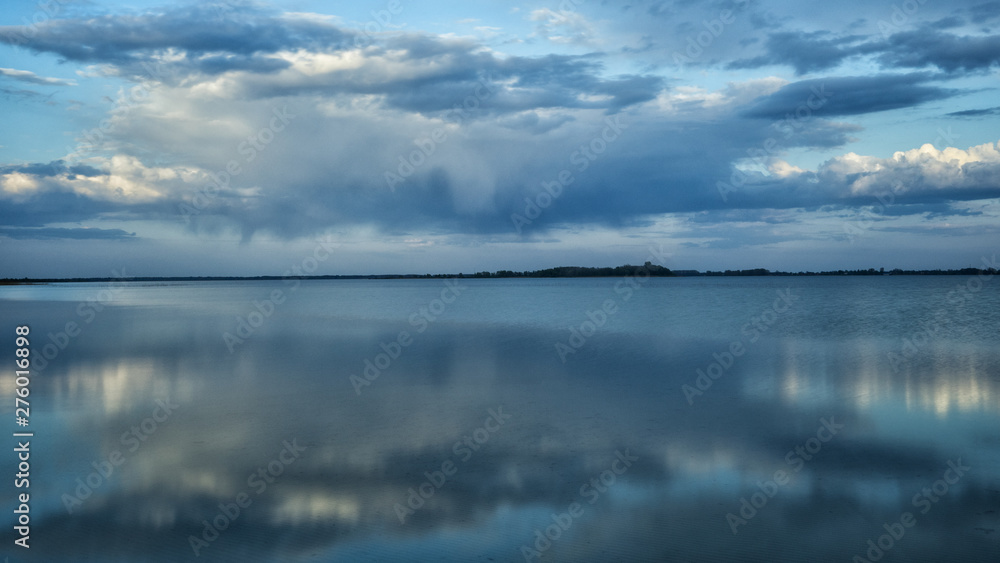Beautiful blue background. Clouds reflected on the water. Switiaz Lake. Polesie. Ukraine
