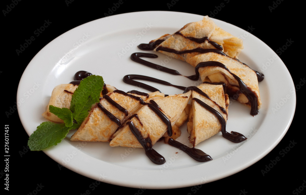 Plate of delicious crepes roll with fresh fruits and chocolate Plate of delicious crepes roll with fresh fruits and chocolate