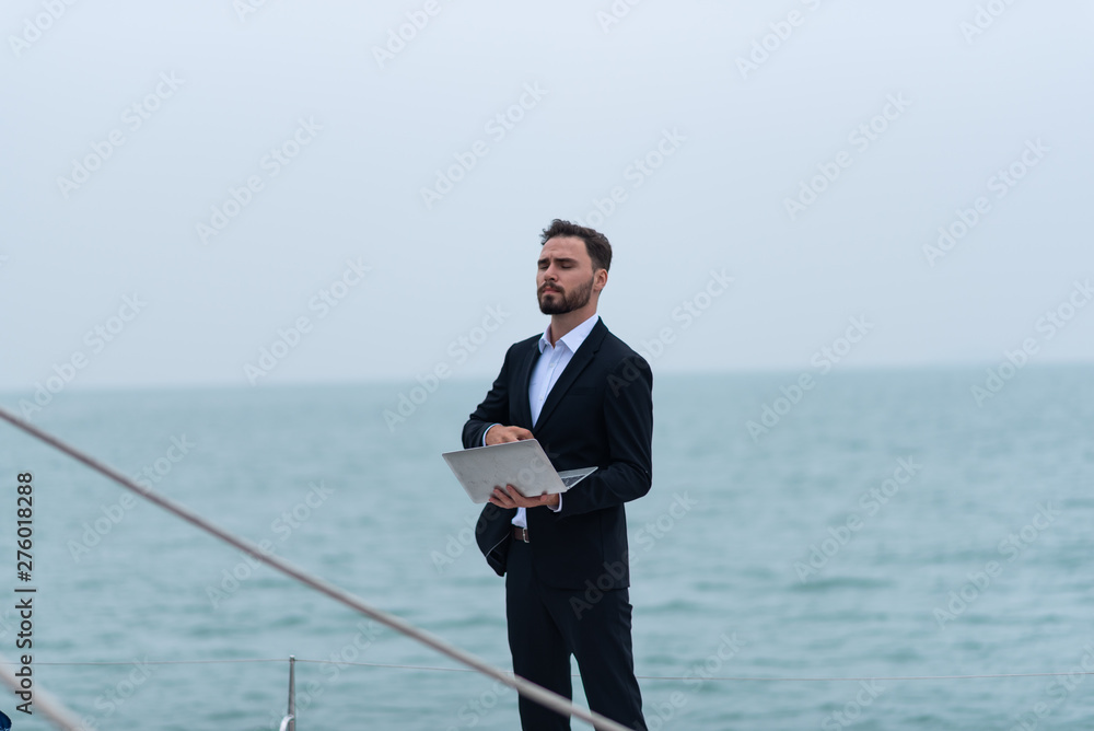 businessman in suit using laptop on yacht boat