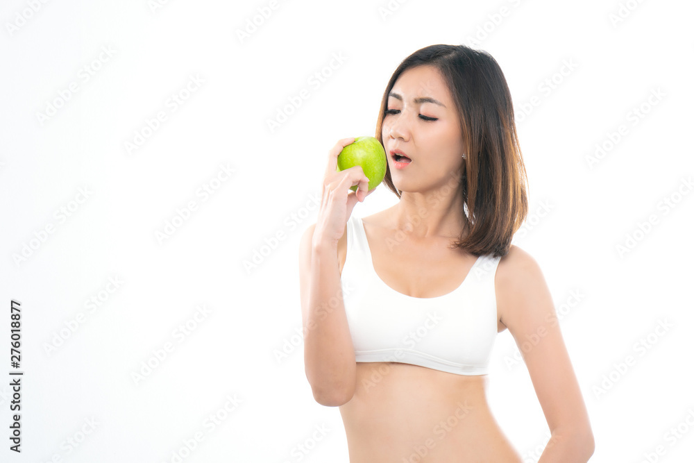 Beautiful asian young woman healthy food in white sport bra eating green apple with healthy food on a white background. Beautiful asian young woman healthy food in white sport bra eating green apple with healthy food on a white background.