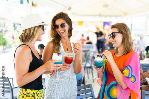 Women drinking cocktails on the party summer holiday day toasting having fun celebrating vacation outdoor bar