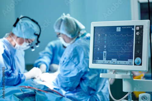 A surgeon's team in uniform performs an operation on a patient at a cardiac surgery clinic. Modern medicine, a professional team of surgeons, health. photo