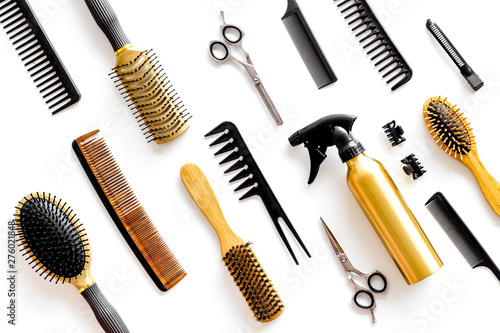 Combs, sciccors and hairdresser tools in beauty salon work desk on white background top view pattern