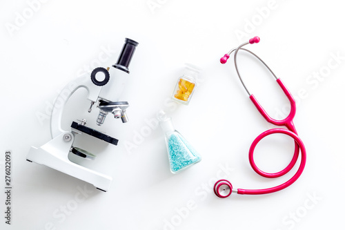 Medical research with microscope, stethoscope, test tube on white background top view