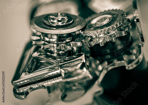 Close-up of can opener wheels and mechanism viewed from top side angle. Monochrome cyan and yellow toned image photo