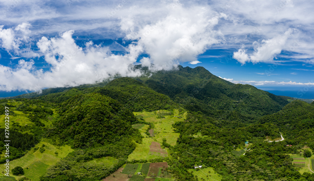 Φωτογραφία Aerial view of lush green farmland and clouds on the slopes of an active volcano
