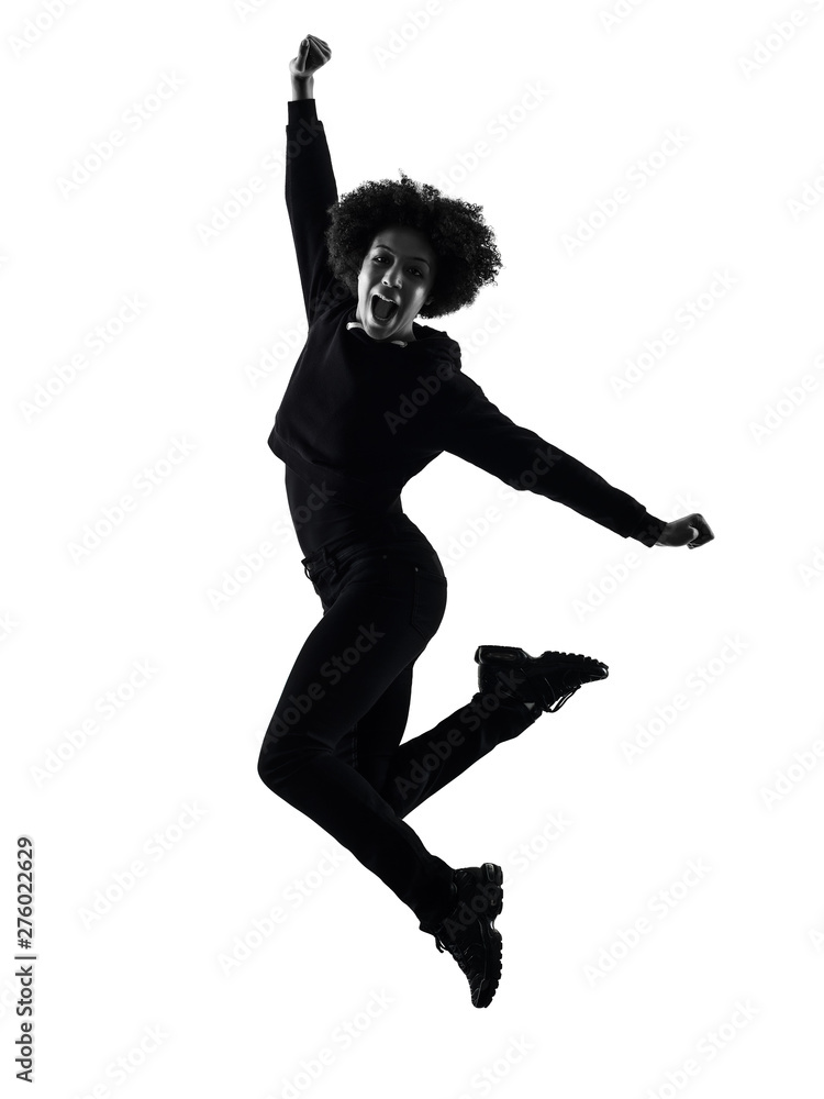 one mixed race african young teenager girl woman jumping happy in studio shadow silhouette isolated on white background