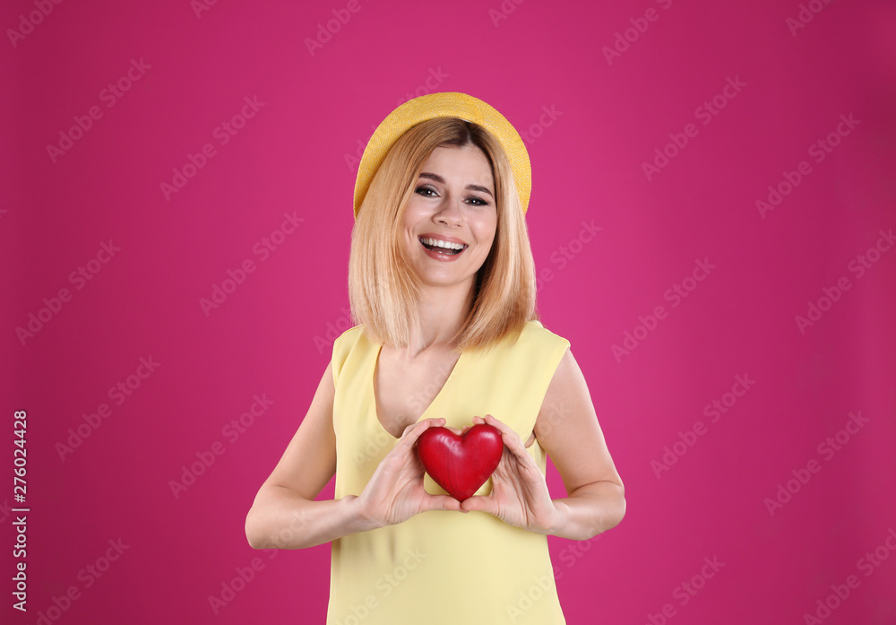 Portrait of beautiful woman holding decorative heart on color background Portrait of beautiful woman holding decorative heart on color background