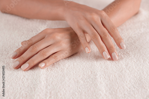 Woman with smooth hands and manicure on towel, closeup. Spa treatment