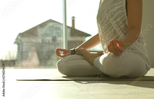 Young woman practicing yoga in sunlit room, closeup with space for text