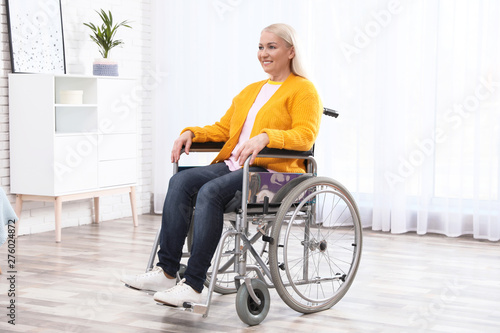 Mature woman sitting in wheelchair at home