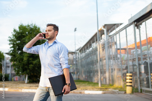 Portrait of sales representative. Logistics manager calling to his business partner to have a deal. Concept of warehouse outdoor and transportation services. .
