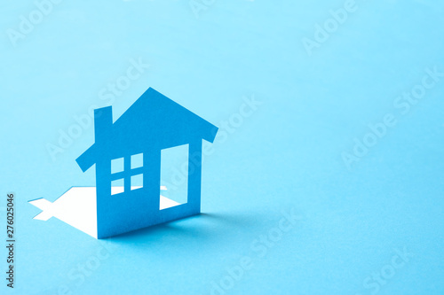 Concept of house in paper on blue color background for real estate property industry photo