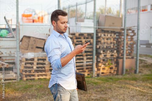 Portrait of sales representative. Logistics manager calling to his business partner to have a deal. Concept of warehouse outdoor and transportation services. .