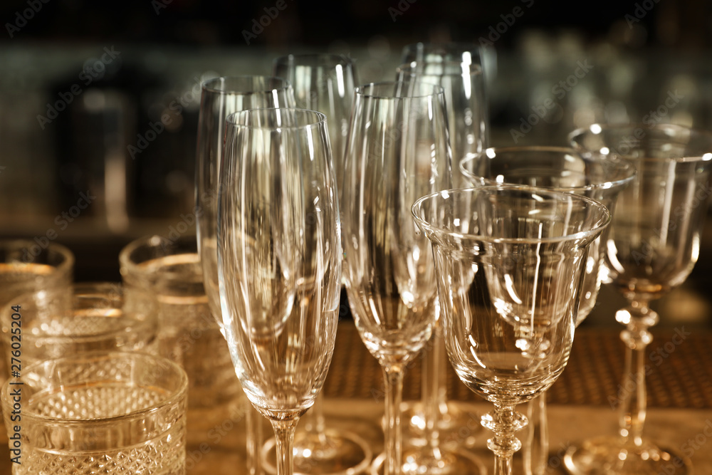 Different empty clean glasses on counter in bar, closeup Different empty clean glasses on counter in bar, closeup